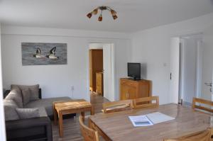 ein Wohnzimmer mit einem Sofa und einem Esstisch in der Unterkunft Seevilla Wietjes Whg 1 in Baltrum