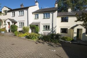 a large white house with a brick driveway at Yewdale Cottage Coniston in Coniston