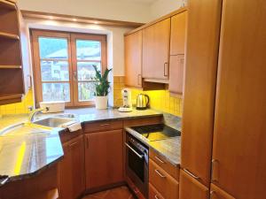 a kitchen with wooden cabinets and a sink at Ferienwohnung Berglust in Sachrang