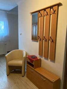 um quarto com uma cadeira, uma cómoda e um espelho em Vila Vodica em Hul