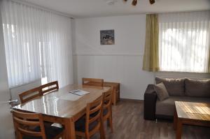uma sala de estar com uma mesa e um sofá em Seevilla Wietjes Whg 1 em Baltrum