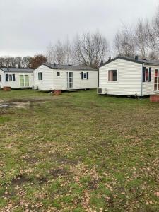 una fila de casas móviles blancas en un campo en Märchencamping, en Stuhr