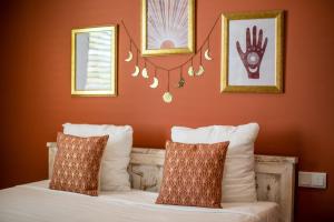Schlafzimmer mit orangefarbenen Wänden und einem Bett mit weißen Kissen in der Unterkunft BOHO Bohemian Boutique Hotel in Willemstad