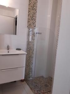 biała łazienka z prysznicem i umywalką w obiekcie Confortable studio bord de mer w mieście Canet-en-Roussillon