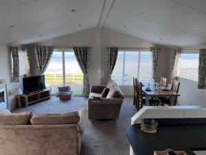 sala de estar con sofás, mesa y TV en Beautiful 2-Bedroom Lodge with Spectacular Views, en Hartlepool