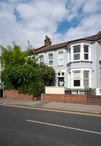 een wit huis aan de kant van een straat bij 1Bed Flat - QUIET Nest - Green Lanes in Londen