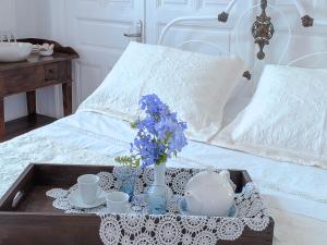Una cama con una bandeja con flores azules. en Anticlea I, en Vathí - Ítaca