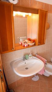 een badkamer met een wastafel en een spiegel bij Panoramic lake view home's Giulia in Casasco Intelvi