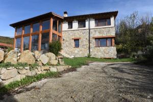 a large stone house with a stone wall at Ecologica casa del sol in Navacepeda de Tormes