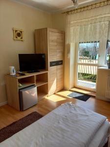 sypialnia z łóżkiem, telewizorem i oknem w obiekcie U Bola w mieście Debrzno