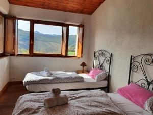 two beds in a room with a window at Ecologica casa del sol in Navacepeda de Tormes