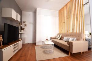 a living room with a couch and a flat screen tv at Alma s HOME, precioso loft en planta primera in Bollullos par del Condado