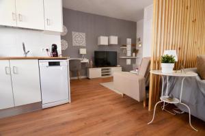 a kitchen and a living room with a table at Alma s HOME, precioso loft en planta primera in Bollullos par del Condado