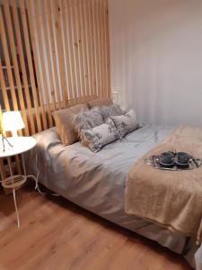 a bed with pillows on it in a room at Alma s HOME, precioso loft en planta primera in Bollullos par del Condado