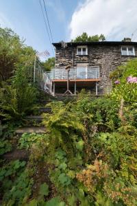a stone house with a staircase leading up to it at Old Quarry Cottage Coniston in Coniston