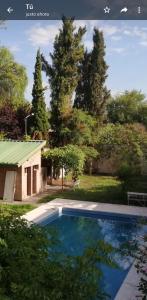 una piscina frente a un patio con árboles en PARAISO en Mendoza