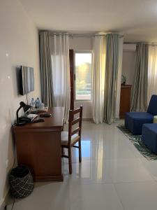 a living room with a desk and a blue couch at Inhambane Hotel Escola in Inhambane