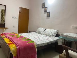 a small bedroom with a bed and a table at Blue King in Jaipur