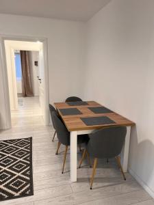 a dining room table with two chairs and a table and a rug at Apartament English Home 2 camere Brasov in Braşov