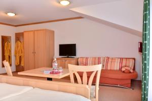 um quarto com uma cama, uma mesa e um sofá em Hotel Sonnfeld em Hinterstoder