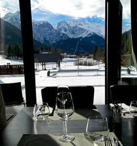 a table with wine glasses on a table with a view at Hôtel Restaurant Le Madame in La Ferrière