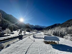 uma montanha coberta de neve com o sol no céu em Hôtel Restaurant Le Madame em La Ferrière