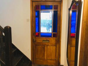a wooden door with stained glass windows next to a staircase at Universal Harmony Retreats Glastonbury in Glastonbury