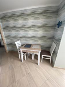 a table and two chairs in a room with a painting at Apartament Vasilya Porika 48 Street Vinnitsya in Vinnytsya