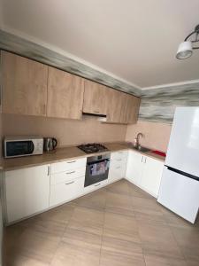 a kitchen with white cabinets and a stove top oven at Apartament Vasilya Porika 48 Street Vinnitsya in Vinnytsya