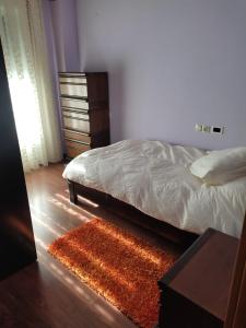 a bedroom with a bed and a rug and a dresser at Duplex Boñar in Boñar