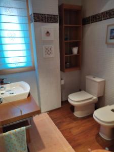 a bathroom with a toilet and a sink at Duplex Boñar in Boñar