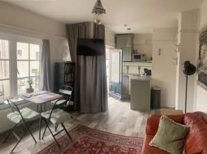 een woonkamer met een bank en een tafel en een keuken bij city-apartment een hele verdieping voor jezelf midden in het centrum in Apeldoorn