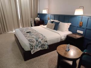 um quarto de hotel com uma cama grande e uma mesa em Hotel TSG Grand em Port Blair