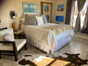1 dormitorio con 1 cama y 1 silla en Desert Oasis - Joshua tree peaceful retreat Home, en Yucca Valley