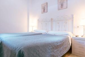 A bed or beds in a room at Apartamento con encanto en patio sevillano (202)