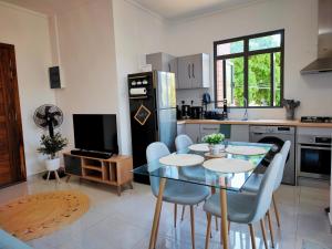 una cucina con tavolo, sedie e frigorifero di Villa La Tortue - GBH a Grand Baie