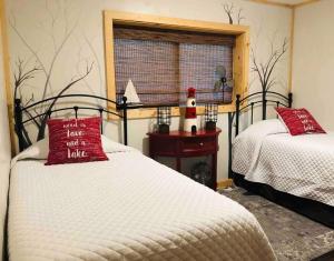 1 dormitorio con 2 camas con almohadas rojas y ventana en Cabin at the cove at Watauga Lake en Butler