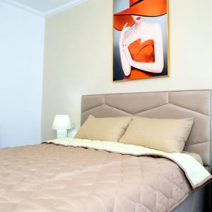 una camera da letto con un letto e un dipinto sul muro di Dolce Casa a Korçë