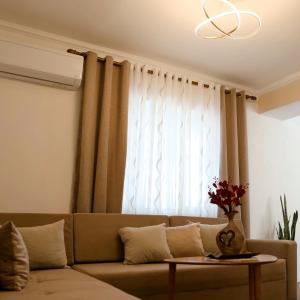 un soggiorno con divano e finestra di Dolce Casa a Korçë