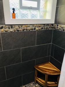 a bathroom with a black tiled wall and a window at Cabin at the cove at Watauga Lake in Butler