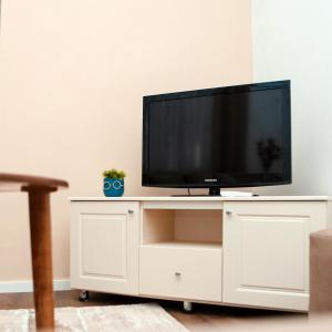 a tv on a white cabinet with a tv on it at Dolce Casa in Korçë