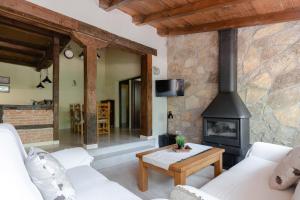 salon z kominkiem i kanapą w obiekcie El Manantial Del Fresno Casas Rurales En Hervás - Piscina - Desayunos - Barbacoa - Parking gratis w mieście Hervás