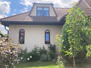 una casa con 3 ventanas y techo en Spacious villa with an outdoor pool in Černošice, en Černošice