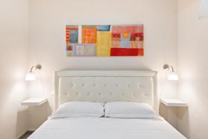 a bedroom with a white bed with two lamps at Il Palazzo della Signoria Modern Loft in Florence
