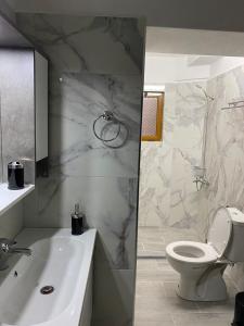ein Badezimmer mit einem Waschbecken, einem WC und einer Badewanne in der Unterkunft Dolce Casa in Korçë