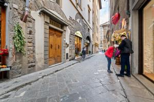 2 personnes debout dans une rue dans une ruelle dans l'établissement Il Palazzo della Signoria Modern Loft, à Florence