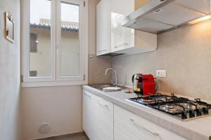 a kitchen with a stove and a red appliance at Il Palazzo della Signoria Modern Loft in Florence +9 photos