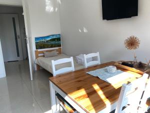 a living room with a table and chairs and a couch at Apartament " POD NIEBIESKIM PAGAJEM " in Mrągowo