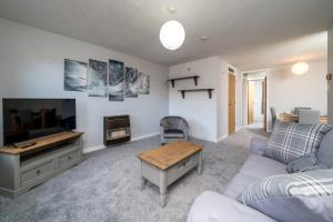 a living room with a couch and a tv at Spacious Pet-Friendly Apartment in Crawley by Sublime Stays in Three Bridges