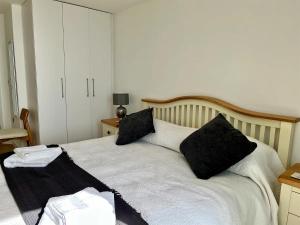 a bedroom with a bed with black pillows on it at SoHot Stays Royal Sands Seaview Apt Free Parking Sleeps 4 in Ramsgate